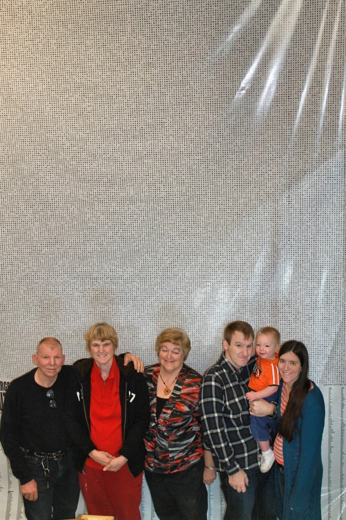 Mel Crow, third from right, with family in front of his world-record wordsearch puzzle.