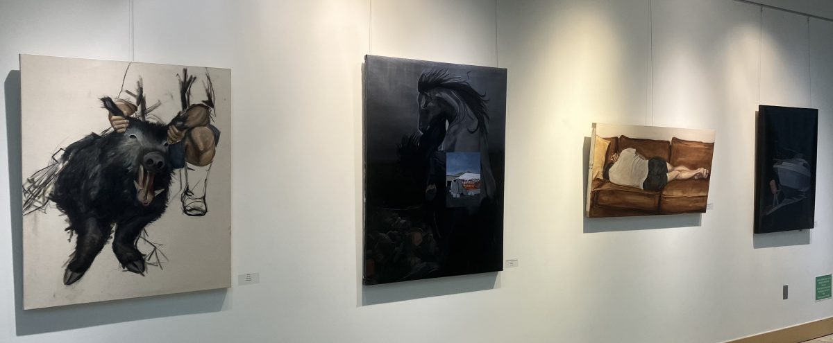 Gallery wall displaying several paintings, including a large dark canvas, a reclining figure on a couch, and other figurative works, evenly spaced under track lighting.