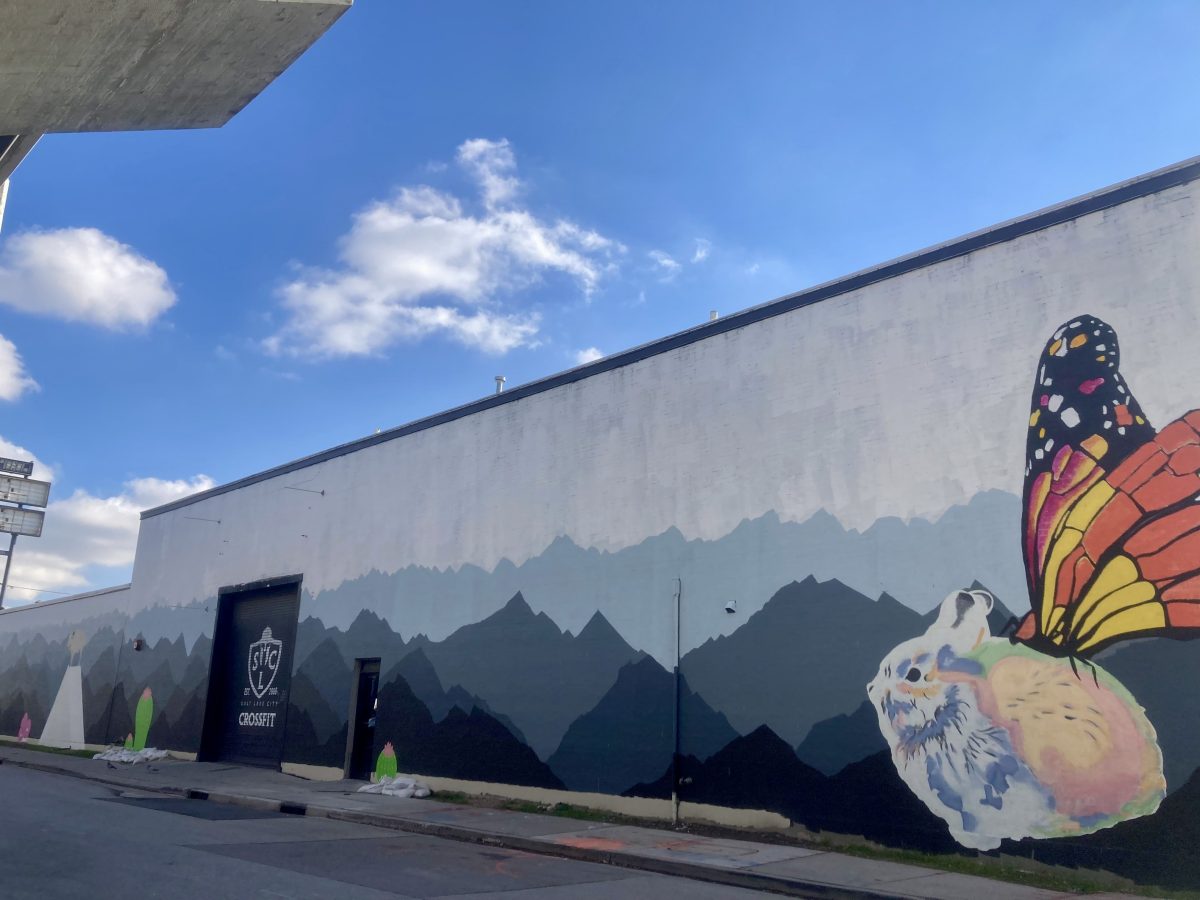 Exterior wall mural at 6th and 6th Studios showing layered mountain silhouettes and a large painted rabbit with monarch butterfly wings on an industrial building.