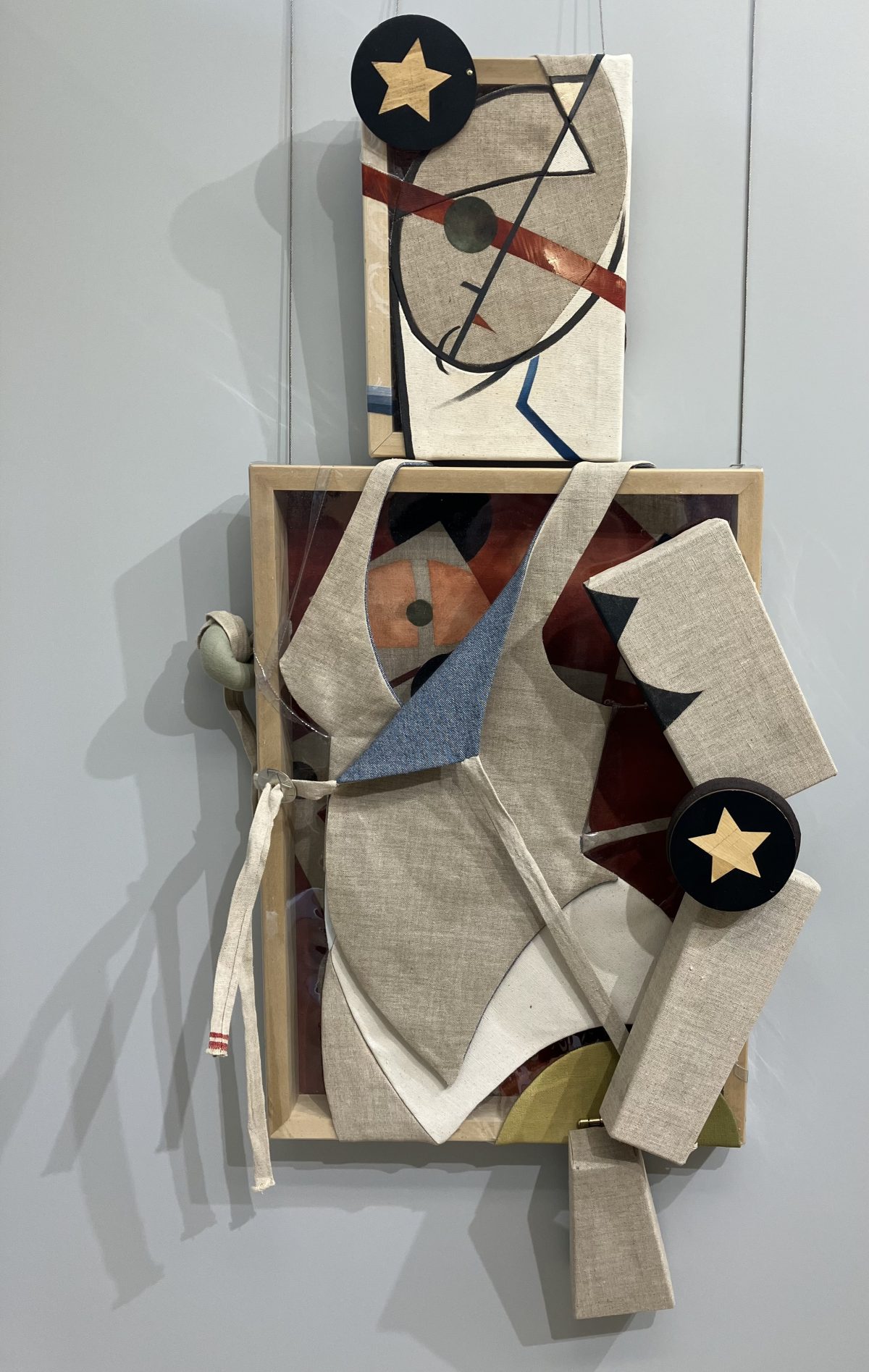 A mixed-media assemblage by Jann Haworth titled "Mannequin Defector," featuring a fragmented figure constructed from canvas, fabric, and wood, with geometric and abstract elements.