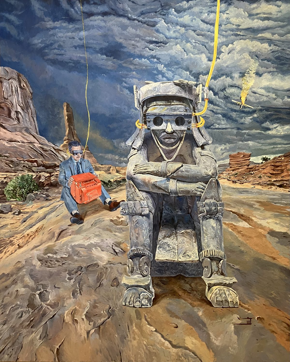 A surreal desert scene where a gray stone Mesoamerican figure wearing futuristic goggles sits solemnly in the foreground, wired to yellow cables; beside it, a suited man with similar eyewear holds a bright red device as a plane crashes in the stormy sky behind.