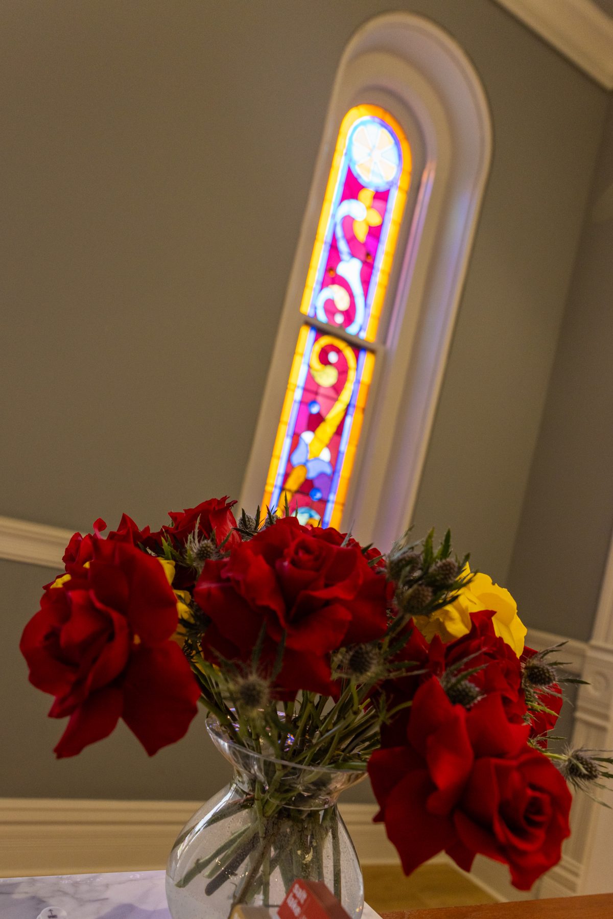 Close-up of colorful stained-glass window panels in the B’nai Israel Temple featuring blue, red, yellow, and green glass.